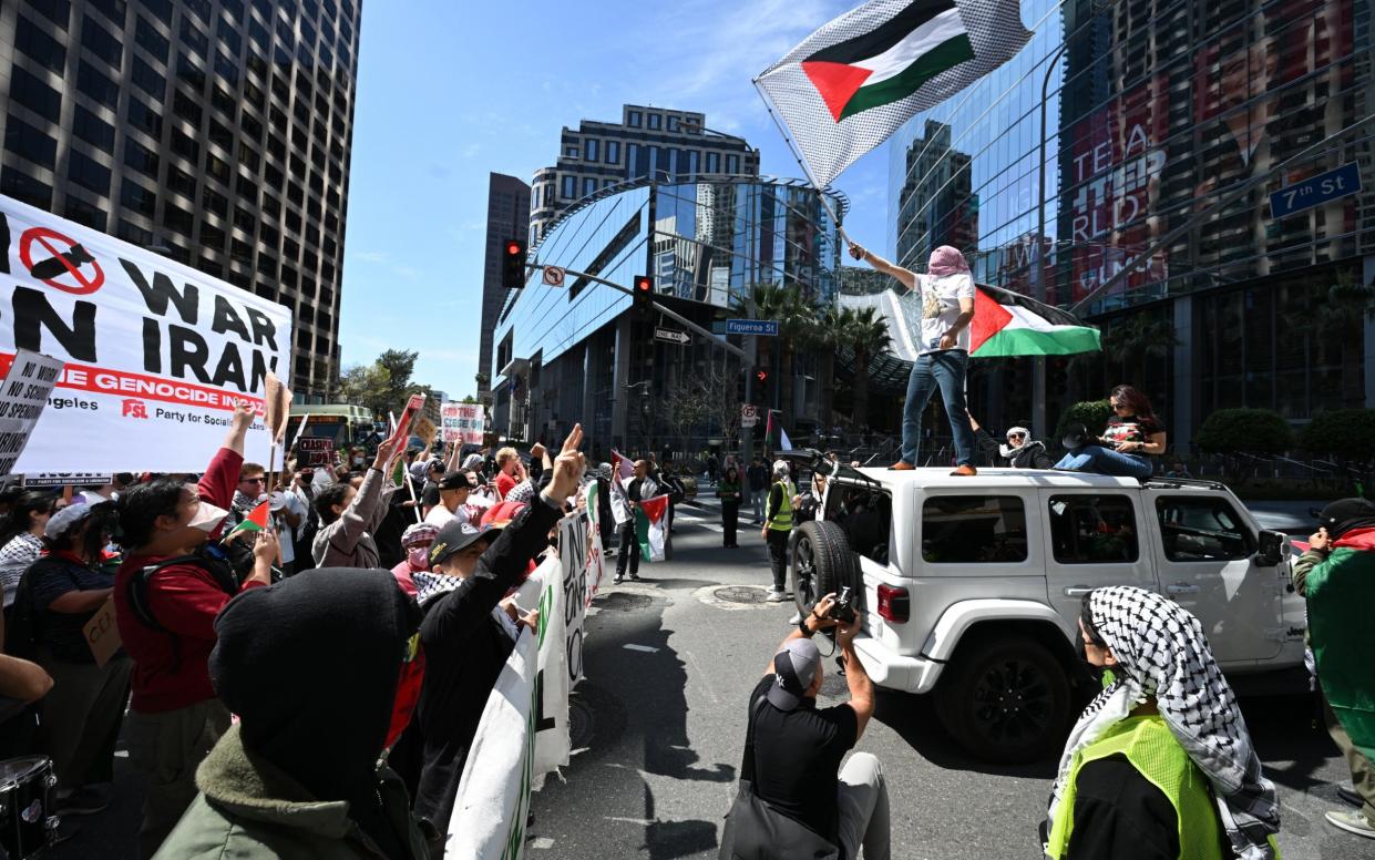 Demonstrators wave flags and temporarily block and intersection in downtown Los Angeles during a "Strike for Gaza" protest