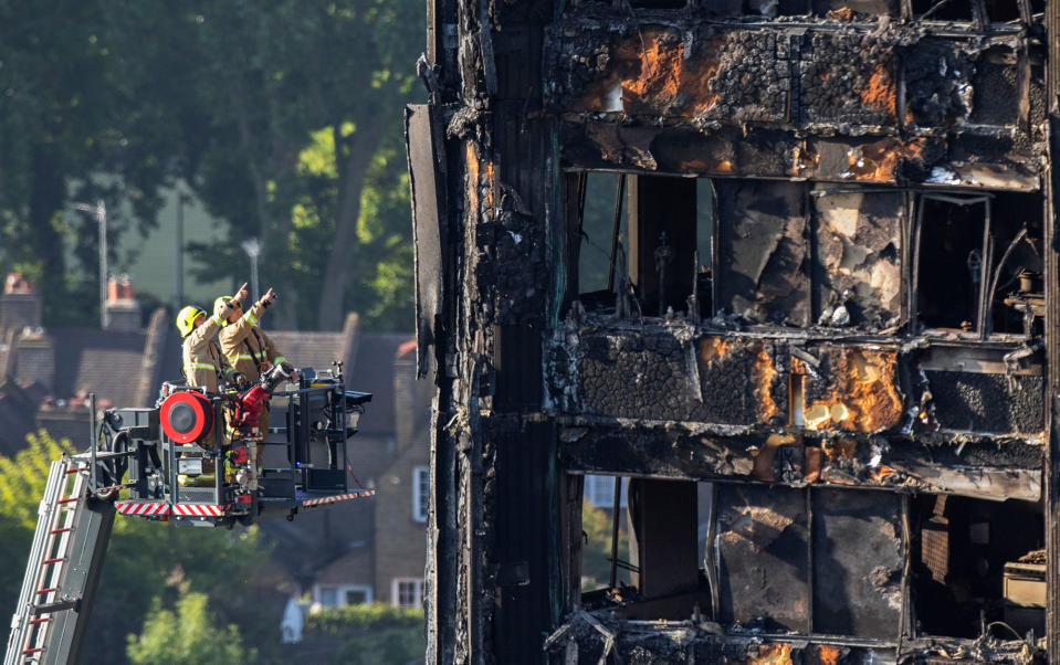 <p>Firefighters survey the damage to the fire-gutted Grenfell Tower in London, (Photo: Rick Findler/ PA via AP) </p>