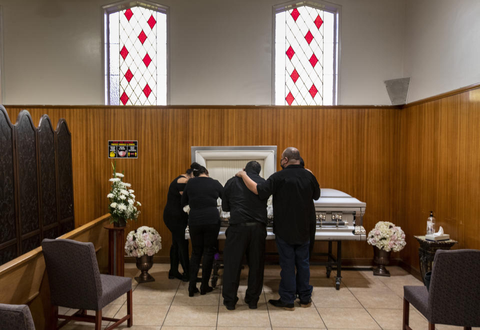 EAST LOS ANGELES, CA - DECEMBER 20: Family members gather to mourn Edith Fernandez alongside her casket at the Continental Funeral Home on Sunday, Dec. 20, 2020 in East Los Angeles, CA. The 47-year-old died Dec. 8, 2020 from complications of Covid-19. (Brian van der Brug / Los Angeles Times via Getty Images)