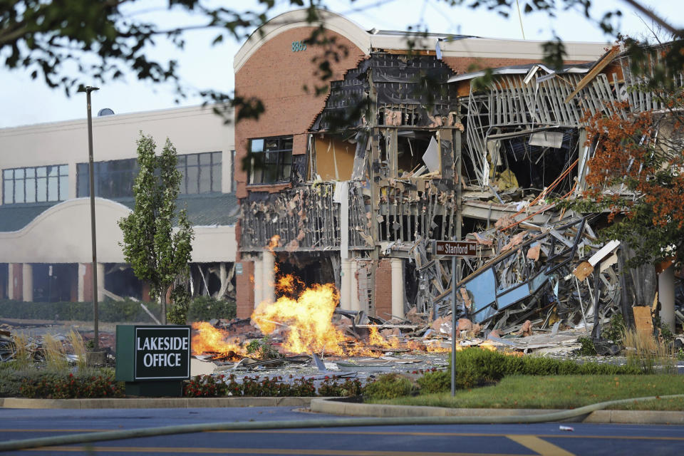 This photo provided by the Howard County Fire And Rescue shows the scene of a damaged building and burning debris nearby after an explosion at an office complex and shopping center in Columbia, Md., Sunday, Aug. 25, 2019. (Howard County Fire And Rescue via AP)