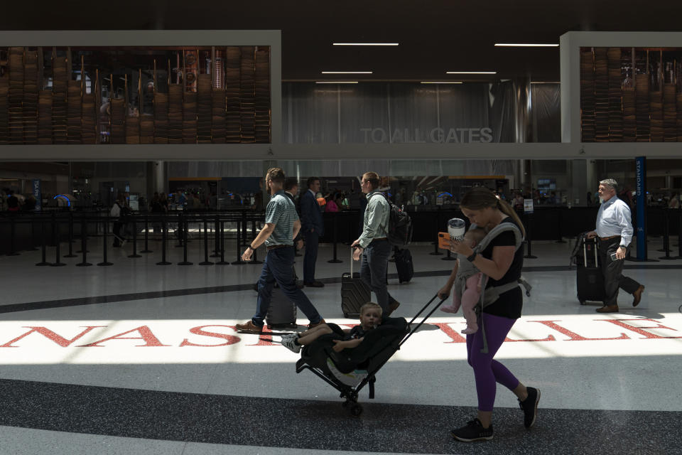 Travelers make their way through the Nashville International Airport Thursday, May 25, 2023, in Nashville, Tenn. (AP Photo/George Walker IV)