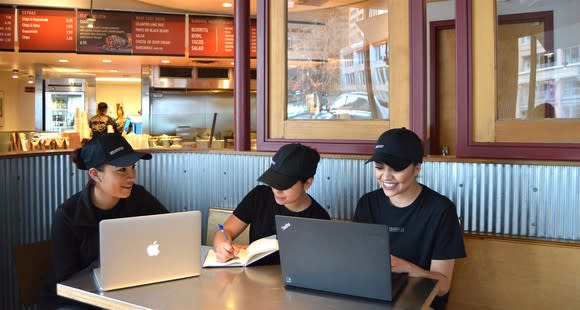 New Chipotle employees training at a restaurant.