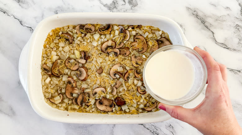 pouring cream into vegetable orzo