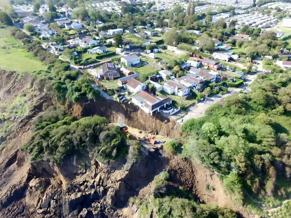  Shocking new photos show a house teetering on the edge of a cliff, after a dramatic collapse forced the evacuation of 20 houses in Eastchurch, Kent. May 31 2020. See SWNS story SWNNcliff. Shocking new photos show a house teetering on the edge of a cliff, after a dramatic collapse forced the evacuation of 20 houses. Drone footage shows a home - in Eastchurch, Kent - hanging off the edge off the cliff, with cars also tumbling down the slope. Up to three metres of land in front of the property fell away on Friday night after years of erosion. While all but two of the households were able to return home yesterday, several were left without electricity as a result of the incident - and one is at serious risk of collapsing into the sea.