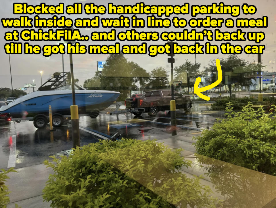 A SUV is towing a Yamaha AR240 boat in a rainy parking lot seen through a window with green shrubs in the foreground