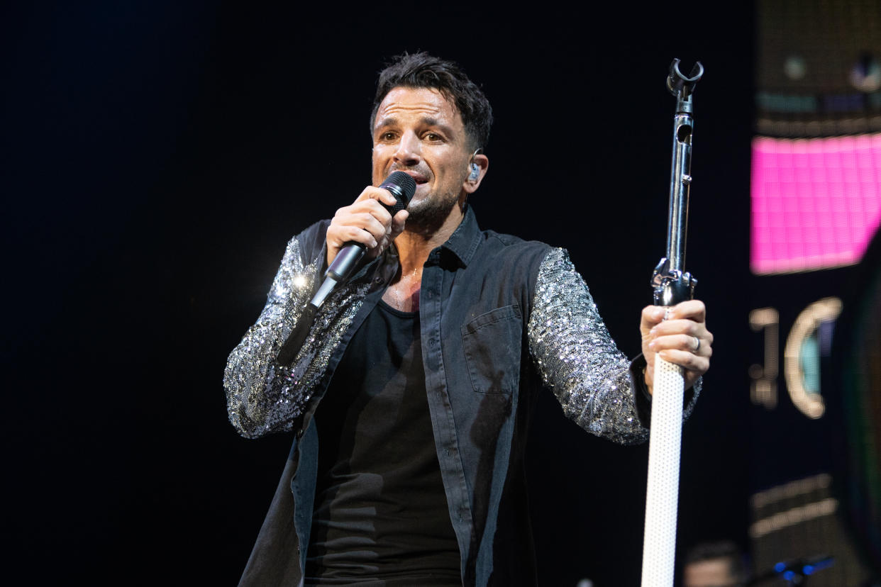 Peter Andre performing in 2018 with straight hair.