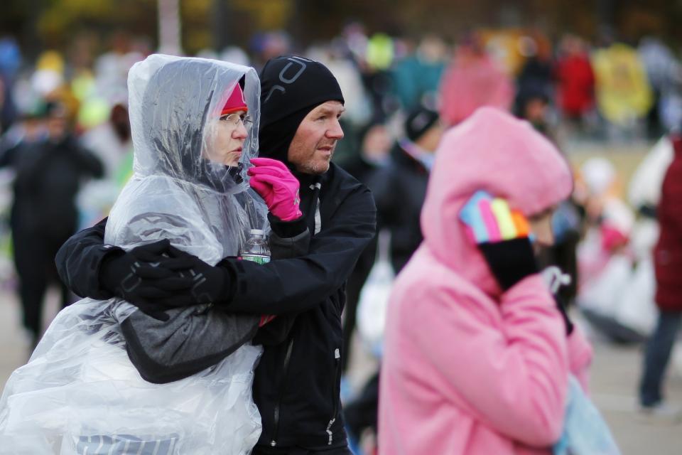 Runners cover themselves from the low temperatures and strong wind before the start of the New York City Marathon in New York, November 2, 2014. . REUTERS/Eduardo Munoz (UNITED STATES - Tags: SPORT ATHLETICS)