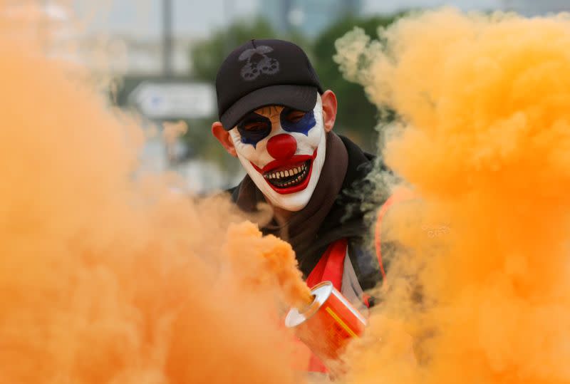 Un manifestante es visto entre el humo mientras los miembros de los sindicatos franceses se manifiestan contra los planes de reforma de las pensiones del gobierno francés en Marsella