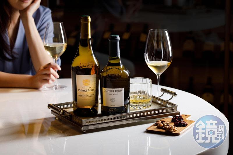 單杯酒款推出侏羅產區酒款，如產自夏隆堡區的黃酒「Domaine Désiré Petit Château Chalon En Baumont 2013（右，680元／杯）」，帶有礦物鹹韻，內行人會搭配帶殼海鮮料理；「Domaine Désiré Petit Savagnin 2016」（左，550元／杯）只比正統黃酒早2年裝瓶，因而有黃酒前身的暱稱，散發醃菜風味。