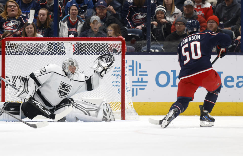 Los Angeles Kings goalie Jonathan Quick, left, makes a stop in front of Columbus Blue Jackets forward Eric Robinson during the first period of an NHL hockey game in Columbus, Ohio, Sunday, Dec. 11, 2022. (AP Photo/Paul Vernon)