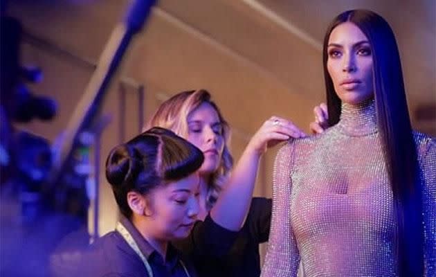 Kim being fitted in the sheer sparkly dress. Source: E!
