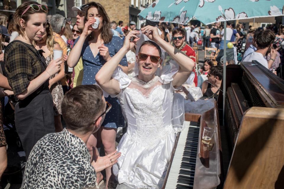 Musical tribute: a well-wisher wears a bridal gown at the piano for the royal wedding street party in Wilton Way, Hackney: Getty Images