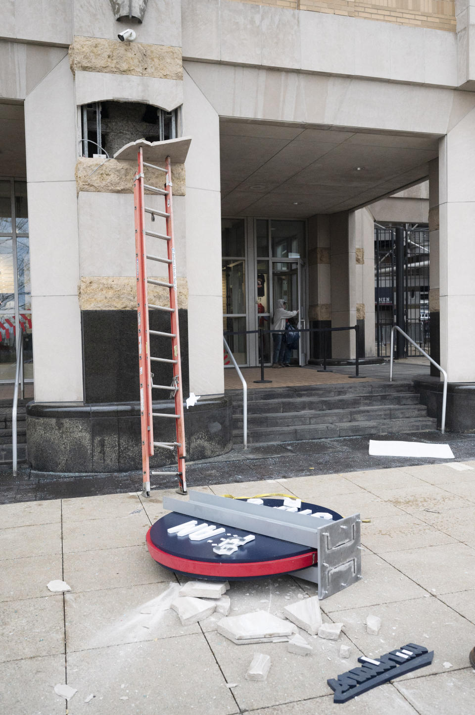 Pieces of the Cleveland Guardians team store sign lie on the ground in Cleveland, Friday, Nov. 19, 2021. The sign was being installed and fell off the building. (AP Photo/Ken Blaze)