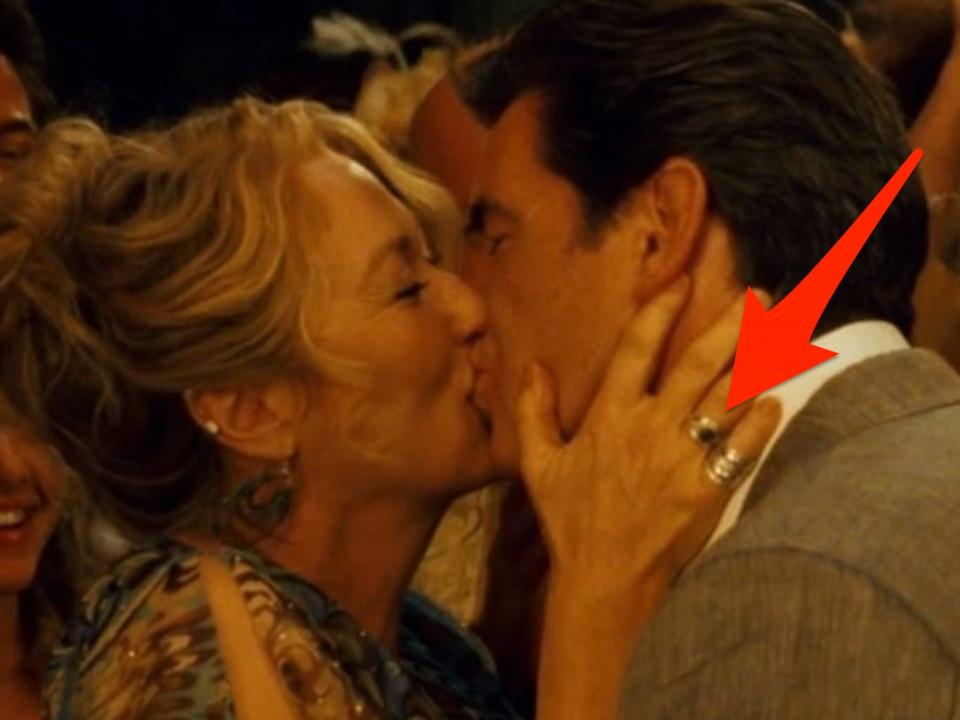 red arrow pointing to a new ring on donna's right hand during the wedding scene in mamma mia