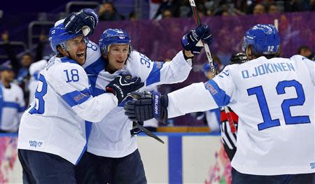 Finland's Juuso Hietanen (C) celebrates his goal against Team USA with teammates Sami Lepisto (L) and Olli Jokinen during the third period of their men's ice hockey bronze medal game at the Sochi 2014 Winter Olympic Games February 22, 2014. REUTERS/Laszlo Balogh