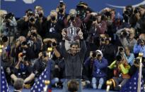 Rafael Nadal of Spain raises his trophy after defeating Novak Djokovic of Serbia in their men's final match at the U.S. Open tennis championships in New York, September 9, 2013. REUTERS/Adam Hunger (UNITED STATES - Tags: SPORT TENNIS)