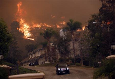 A car drives away from the Colby Fire in hills above Glendora, California January 16, 2014. REUTERS/Mario Anzuoni