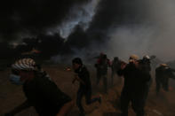 <p>Palestinian demonstrators run for cover during a protest against the U.S. Embassy’s move to Jerusalem and ahead of the 70th anniversary of Nakba, at the Israel-Gaza border in the southern Gaza Strip, May 14, 2018. (Photo: Ibraheem Abu Mustafa/Reuters) </p>