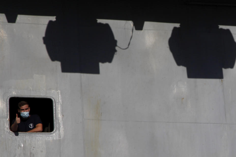 A French crew member is seen of a window on France's nuclear-powered aircraft carrier Charles de Gaulle at Limassol port, Cyprus, Monday, May 10, 2021. With the Task Force's deployment on its mission named "Clemenceau 21," France is assisting in the fight against terrorism while projecting its military power in regions where it has vital interests. (AP Photo/Petros Karadjias)