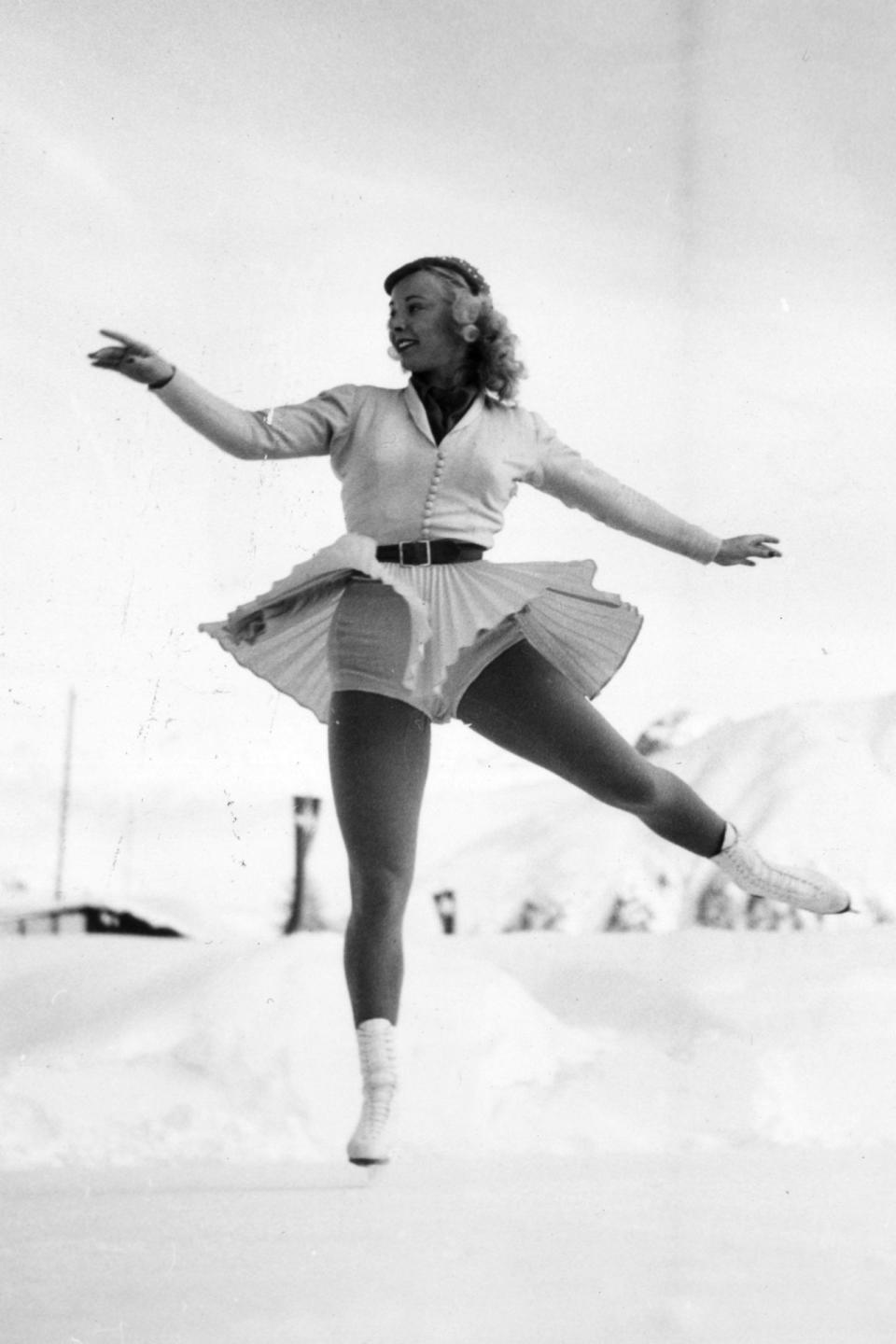 <p>Here, Gretchen Merrill represents the United States at the 1948 Winter Olympics in a white ensemble featuring a pleated skirt and button-down shirt. Belts were common accessories in the earlier years of the Olympics, but started to disappear by the 1960s-70s when one-piece costumes became more common. </p>