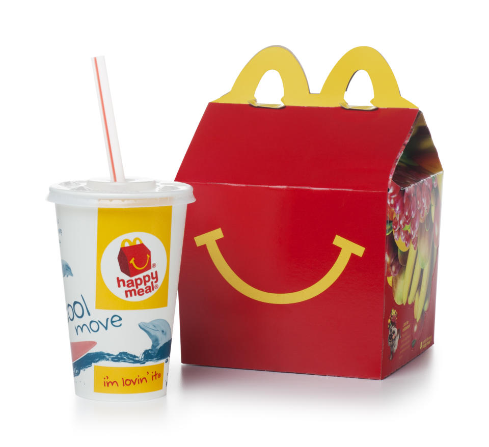 McDonalds Happy Meal in a bright red and yellow box with a smile and the golden arches, plus a small drink cup and straw.