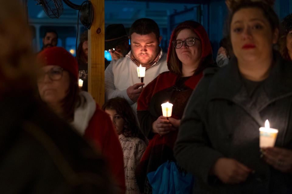 Community members listen during a candlelight vigil for Shannon Hanchett on Monday in Norman.