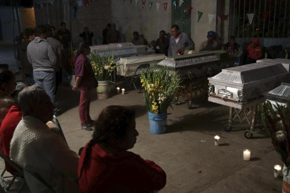 Mourners hold a wake for 11 family members who were killed inside the Santiago Apostol church in Atzala (AP)