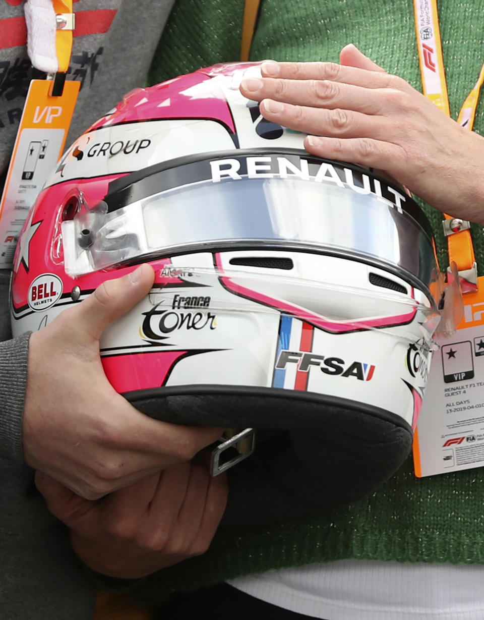 The mother and brother of Anthoine Hubert hold the helmet of Formula 2 driver Anthoine Hubert during a moment of silence at the Belgian Formula One Grand Prix circuit in Spa-Francorchamps, Belgium, Sunday, Sept. 1, 2019. The 22-year-old Hubert died following an estimated 160 mph (257 kph) collision on Lap 2 at the high-speed Spa-Francorchamps track, which earlier Saturday saw qualifying for Sunday's Formula One race. (AP Photo/Francisco Seco)