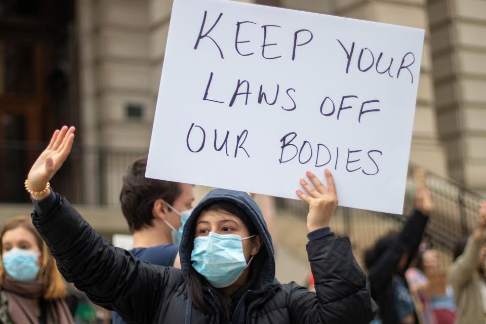 A protester waves at a car that hooks their horns in support of their demonstration outside of the Tippecanoe County Courthouse, in response to the leaked Supreme Court opinion regarding the overturning of Roe v. Wade, on May 3, 2022, in Lafayette.