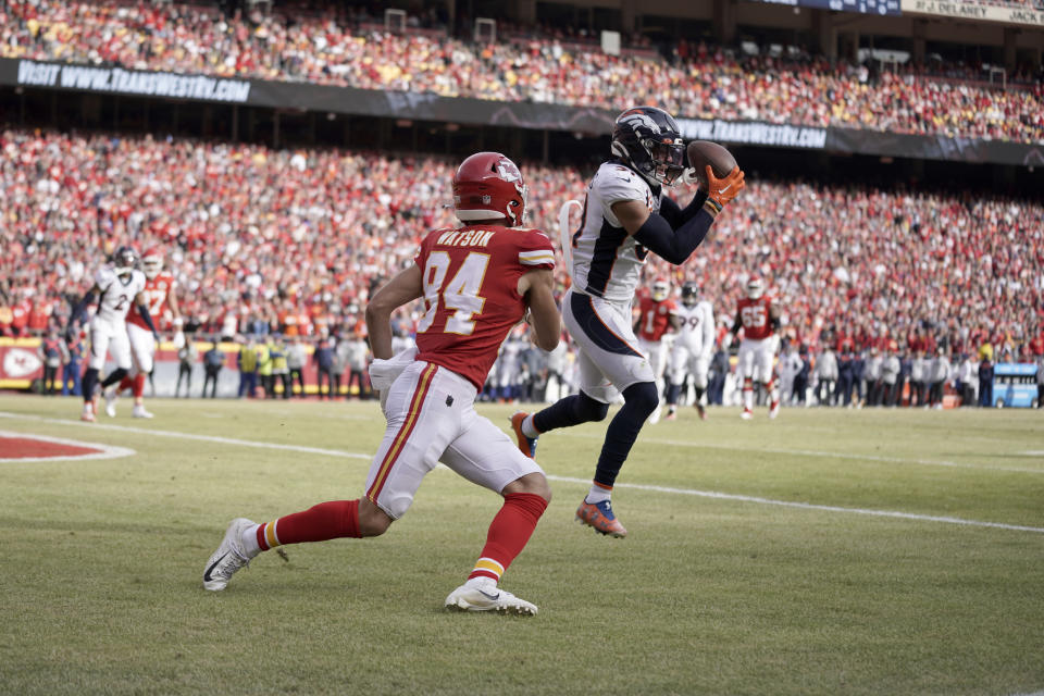 Denver Broncos safety Justin Simmons, right, intercepts a pass intended for Kansas City Chiefs wide receiver Justin Watson (84) during the first half of an NFL football game Sunday, Jan. 1, 2023, in Kansas City, Mo. (AP Photo/Ed Zurga)