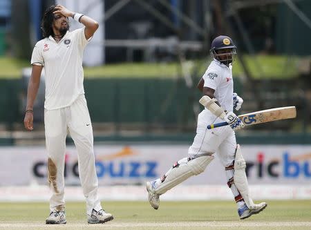 Sri Lanka's Kusal Perera (R) runs between wickets next to India's Ishant Sharma during the third day of their third and final test cricket match in Colombo, August 30, 2015. REUTERS/Dinuka Liyanawatte