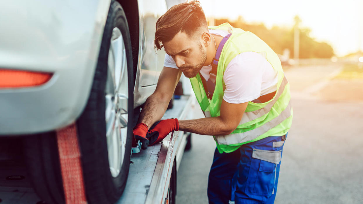 Handsome middle age man working in towing service on the road.