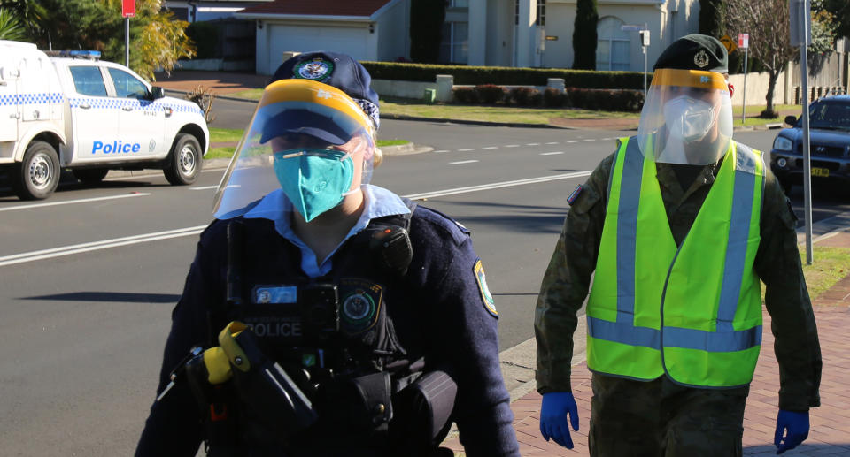A NSW Police officer and ADF troop wear PPE gear while conducting COVID compliance checks in western Sydney. Source: NSW Police 
