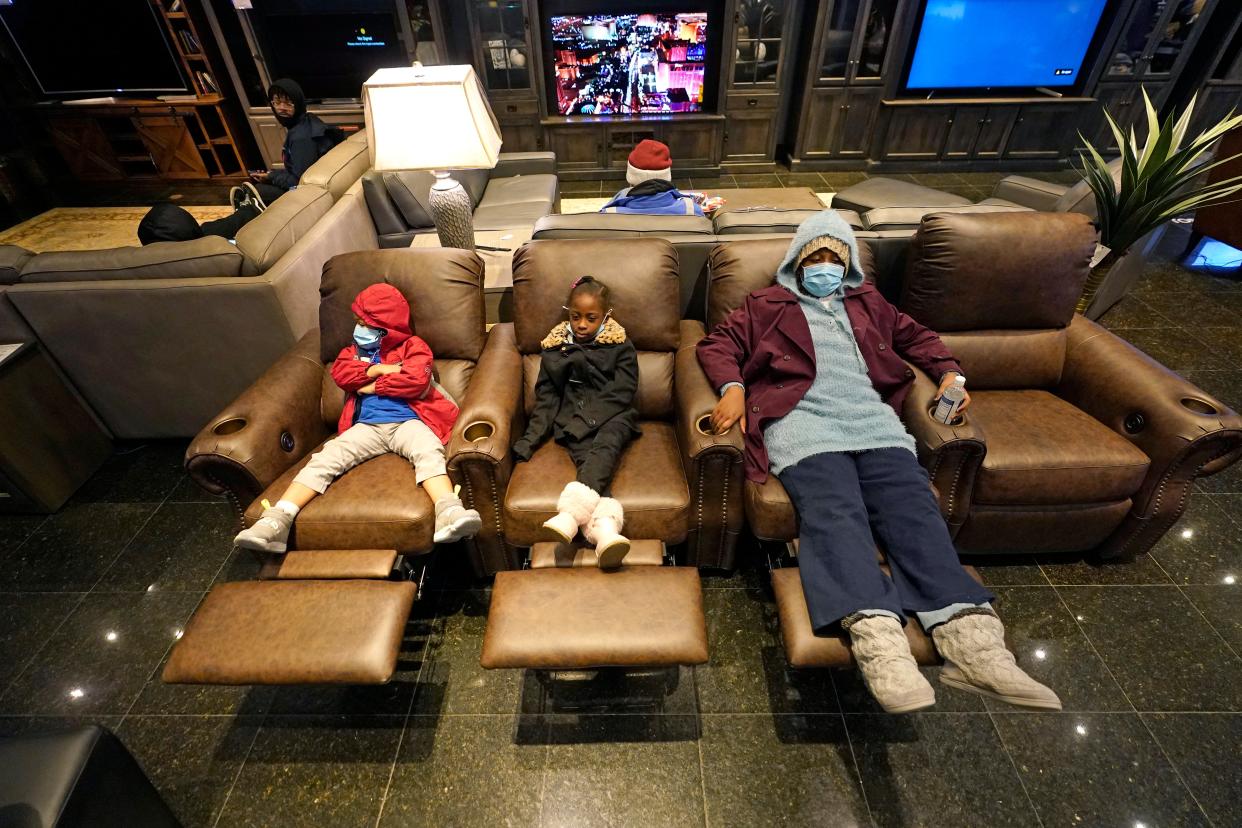 Joecyah Heath, left, Morning Day, center, and Jenesis Heath rest in recliners at a Gallery Furniture store which opened as a shelter Wednesday, Feb. 17, 2021, in Houston. Millions in Texas still had no power after a historic snowfall and single-digit temperatures created a surge of demand for electricity to warm up homes unaccustomed to such extreme lows, buckling the state's power grid and causing widespread blackouts. (AP Photo/David J. Phillip) (AP)