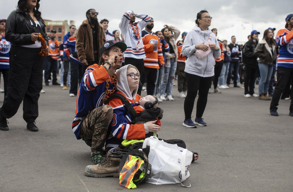 Edmonton Oilers fans watch coverage of Game 5 of the NHL hockey Stanley Cup Final between the Oilers and the Florida Panthers on a large screen Tuesday, June 18, 2024, in Edmonton, Alberta. (Jason Franson/The Canadian Press via AP)