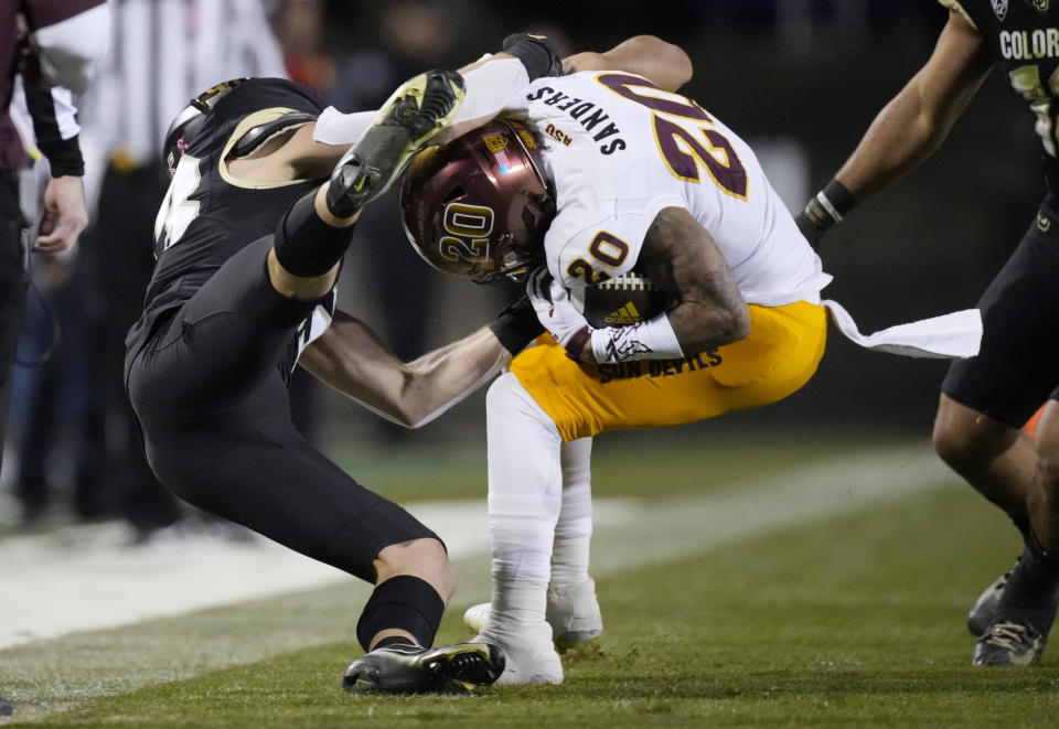 Colorado safety Trevor Woods, left, pulls down Arizona State wide receiver Giovanni Sanders after Sanders caught a pass for a short gain in the second half of an NCAA college football game Saturday, Oct. 29, 2022, in Boulder, Colo. (AP Photo/David Zalubowski)