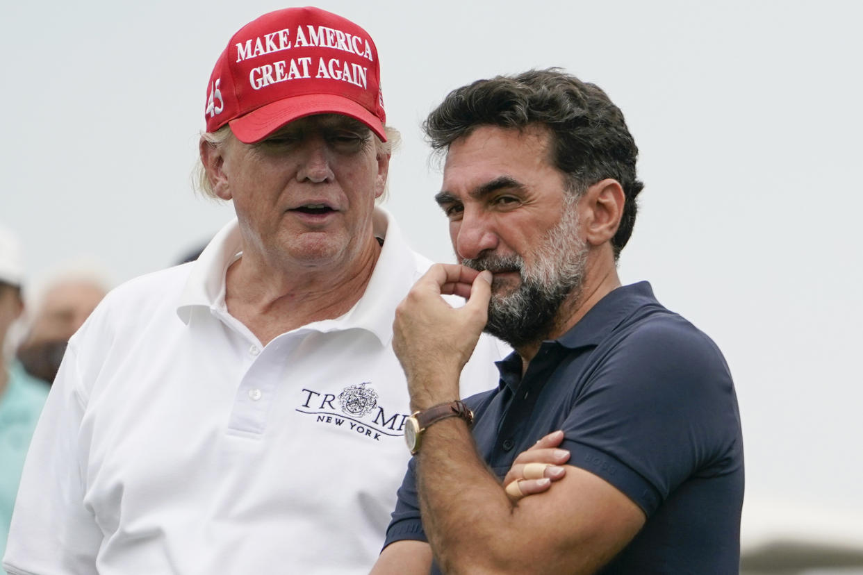 FILE - Former President Donald Trump, left, talks with Yasir Al-Rumayyan, governor of Saudi Arabia's Public Investment Fund, center, and Majed Al-Sorour, CEO of Golf Saudi, on the 16th hole during the first round of the Bedminster Invitational LIV Golf tournament in Bedminster, NJ., July 29, 2022. (AP Photo/Seth Wenig, File)