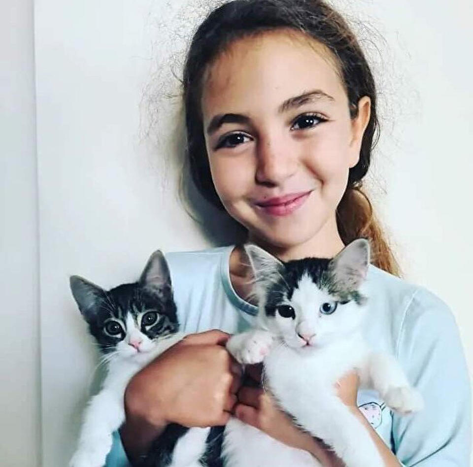 Mahra Melin Pinar, 9, (pictured) holding two kittens before she was hit by a truck while fleeing dogs.