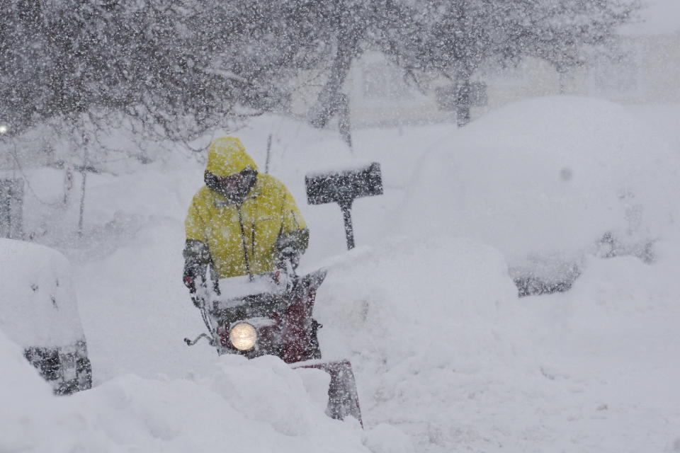 A person uses a blower to clear snow during a storm, Sunday, March 3, 2024, in Truckee, Calif. (AP Photo/Brooke Hess-Homeier)