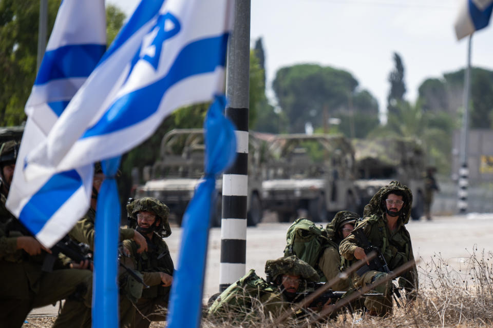 Israeli soldiers guard outside Kibbutz Kfar Aza near the border with Gaza