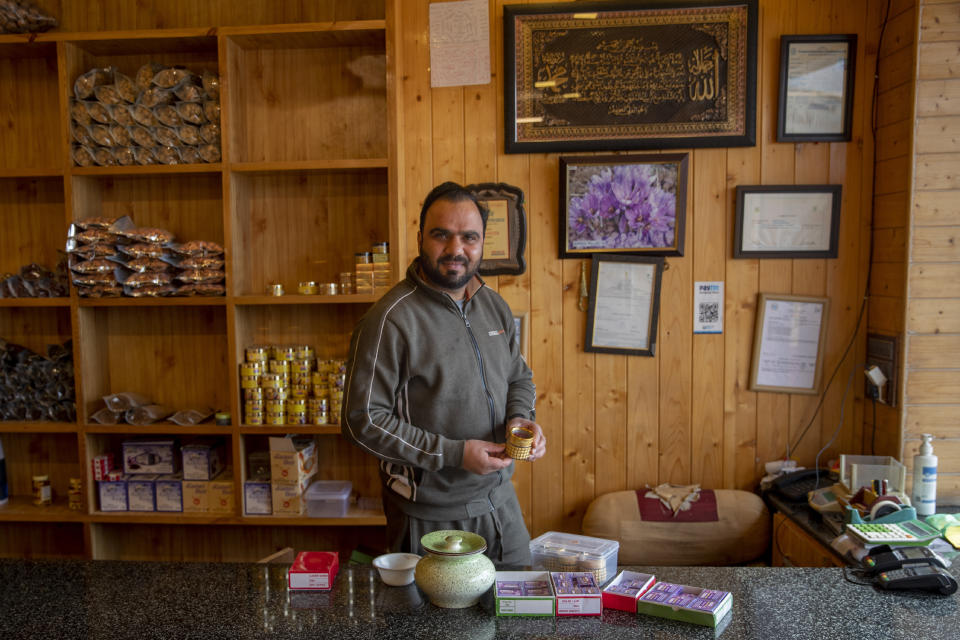 A Kashmiri shopkeeper Shabeeh Farooq displays saffron boxes inside his showroom in Lethpora, south of Srinagar, Indian controlled Kashmir, Saturday, Oct. 31, 2020. Across the world, saffron is used in multiple products ranging from medicine, beauty and food. A kilogram (2.2 pounds) of saffron can easily sell anywhere between $3,000 to $4,000. (AP Photo/Dar Yasin)