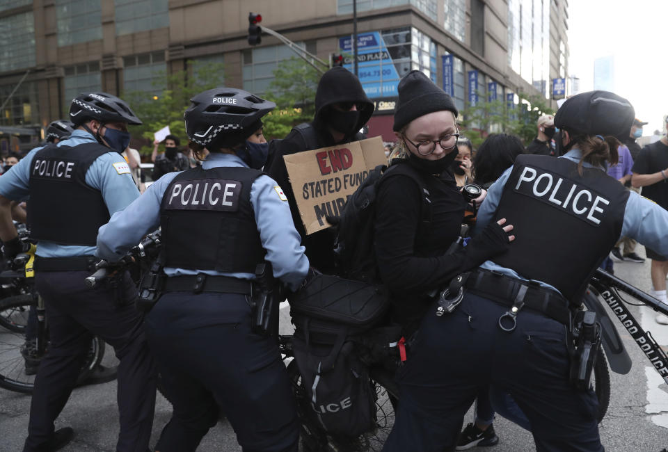 A protester breaks through a police barrier during a march to bring attention to the death of George Floyd in the Loop Friday, May 29, 2020, in Chicago. Floyd died after being restrained by Minneapolis police officers on Memorial Day. (John J. Kim/Chicago Tribune via AP)