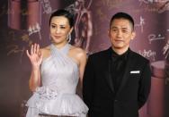 Hong Kong actor Tony Leung, nominated for Best Actor for his role in "The Grandmaster", poses with his wife, actress Carina Lau, on the red carpet during the 33rd Hong Kong Film Awards in Hong Kong April 13, 2014. REUTERS/Tyrone Siu (CHINA - Tags: ENTERTAINMENT)