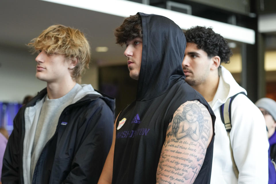 From left, Washington football players Tristan Dunn, Zach Durfee and Maurice Heims watch as head coach Jedd Fisch is introduced during an NCAA college football press conference Tuesday, Jan. 16, 2024, in Seattle. (AP Photo/Lindsey Wasson)