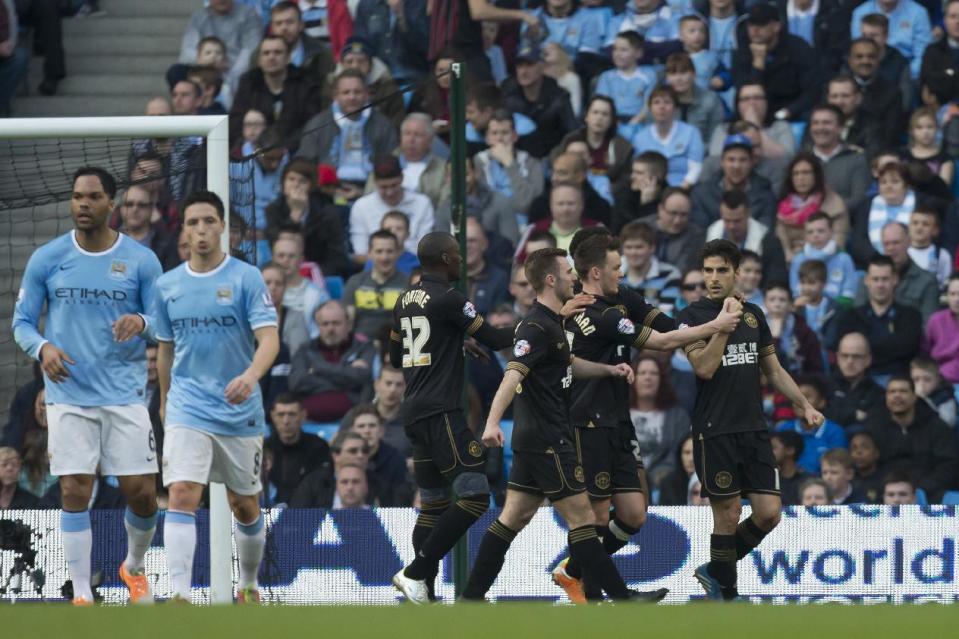 Wigan's Jordi Gomez, right, celebrates with teammates after scoring a penalty against Manchester City during their English FA Cup quarterfinal soccer match at the Etihad Stadium, Manchester, England, Sunday, March 9, 2014. (AP Photo/Jon Super)