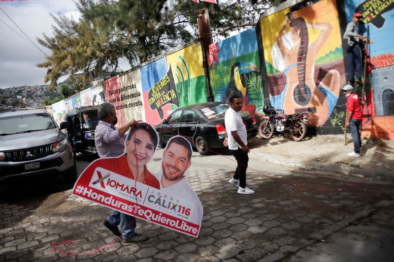 A man holds a poster of the Libre Party presidential candidate Xiomara Castro ahead of the November 28 general election in Tegucigalpa