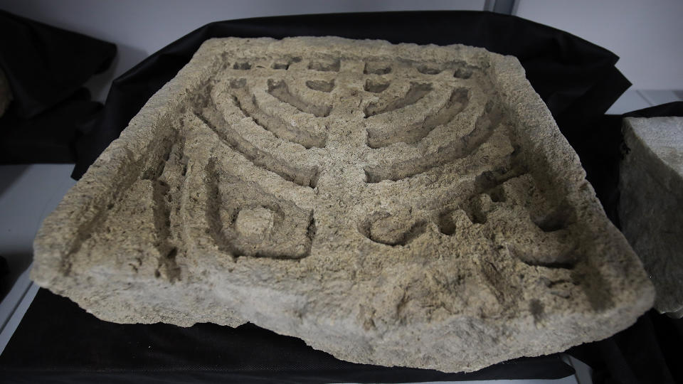 A marble relief of a menorah. This one may have had nine branches, and could be a representation of a hannukiah — a nine-branched menorah used to celebrate Hanukkah.