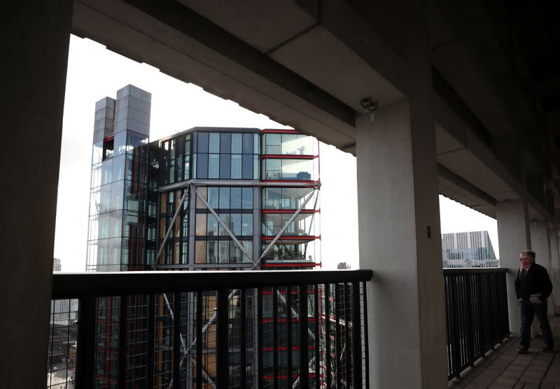 Visitors look out from the Viewing Level towards a luxury block of flats from the Tate Modern gallery in London