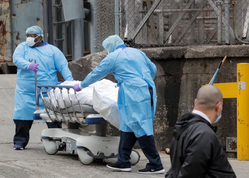 Health workers wheel a deceased person outside the Brooklyn Hospital Center, during the coronavirus disease (COVID-19) outbreak, in the Brooklyn borough of New York