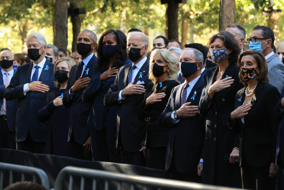 NEW YORK, NEW YORK - SEPTEMBER 11: (L-R) Former President Bill Clinton, former First Lady Hillary Clinton, former President Barack Obama, former First Lady Michelle Obama, President Joe Biden, First Lady Jill Biden, former New York City Mayor Michael Bloomberg, Bloomberg's partner Diana Taylor and Speaker of the House Nancy Pelosi (D-CA) stand for the national anthem during the annual 9/11 Commemoration Ceremony at the National 9/11 Memorial and Museum on September 11, 2021 in New York City. During the ceremony six moments of silence were held, marking when each of the World Trade Center towers was struck and fell and the times corresponding to the attack on the Pentagon and the crash of Flight 93. The nation is marking the 20th anniversary of the terror attacks of September 11, 2001, when the terrorist group al-Qaeda flew hijacked airplanes into the World Trade Center, Shanksville, PA and the Pentagon, killing nearly 3,000 people. (Photo by Chip Somodevilla/Getty Images)